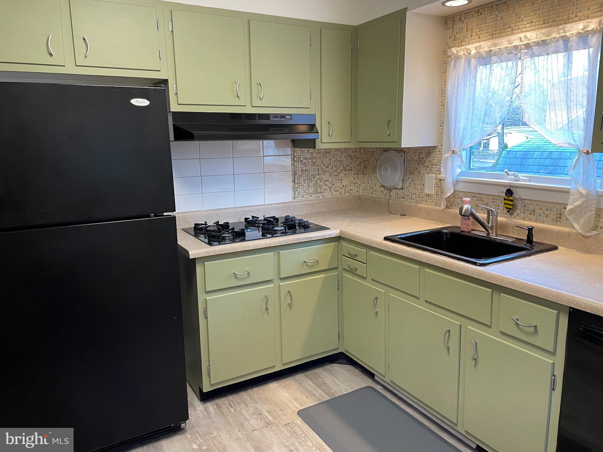 2400 Edge Hill Road Willow Grove, PA 19090 - Photo 21 of 43 a kitchen with white cabinets and black appliances