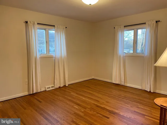 a view of a room with wooden floor staircase and a window