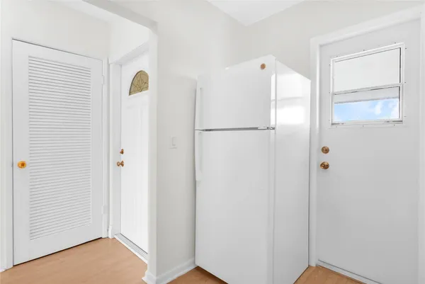 a kitchen with white cabinets and white appliances