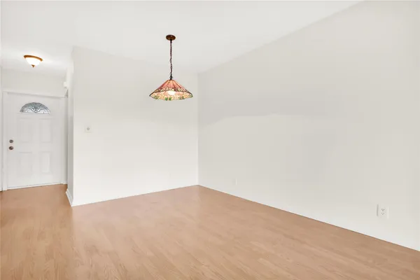 an empty room with windows and ceiling fan