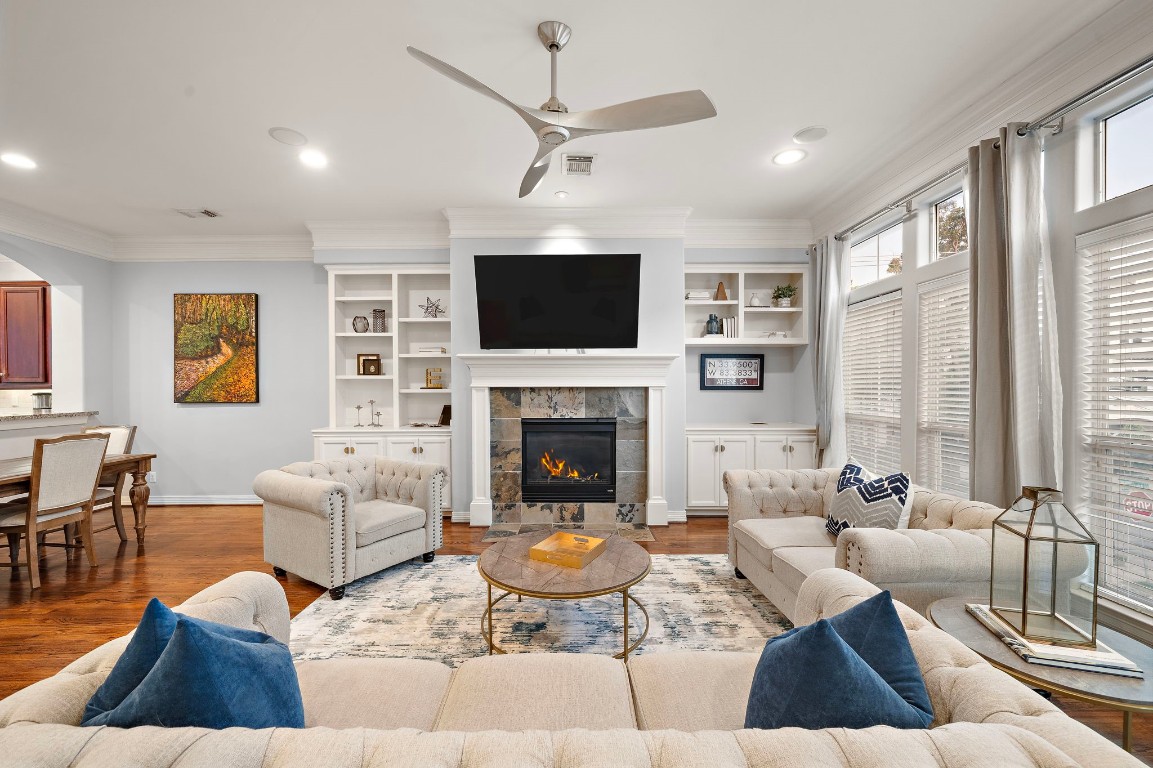 Rows of oversized windows and elegant crown molding combine with gleaming hardwood floors to create an inviting, timeless space ideal for relaxation and gatherings.