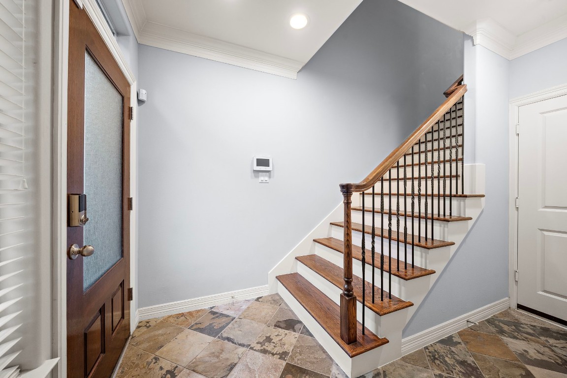 3929 Floyd Street Houston, TX 77007 - Photo 12 of 42 Classic foyer greets guests with beautiful stone-look tile flooring and elegant hardwood stairs accented by wrought-iron balusters.