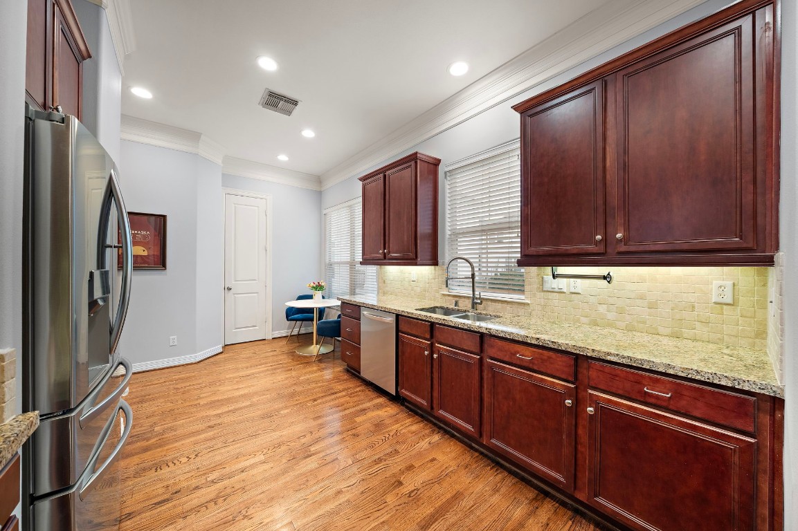 3929 Floyd Street Houston, TX 77007 - Photo 18 of 42 Warm wood cabinetry, granite countertops, and stainless steel appliances create a functional kitchen hub with under-cabinet lighting and abundant storage.