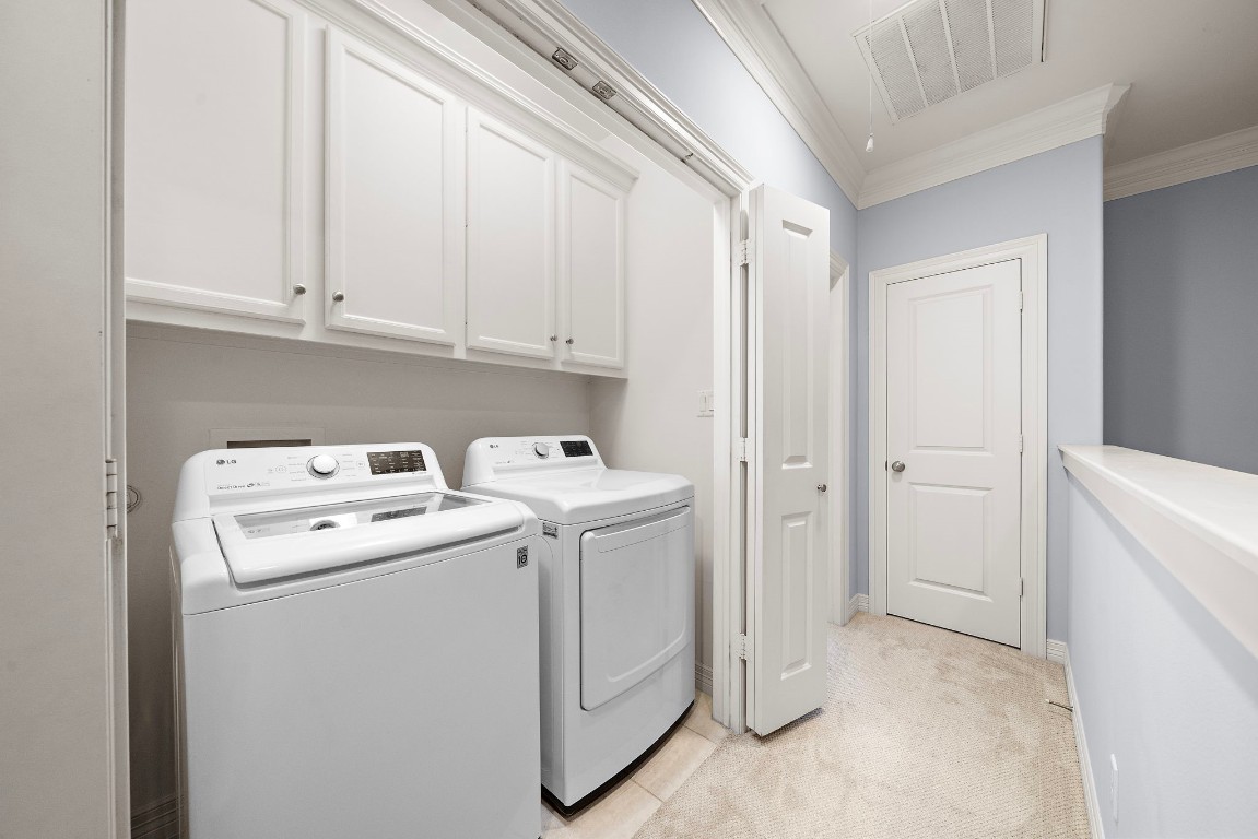 3929 Floyd Street Houston, TX 77007 - Photo 32 of 42 Upstairs laundry area offers built-in cabinetry for practical storage, keeping detergents and essentials out of sight.
