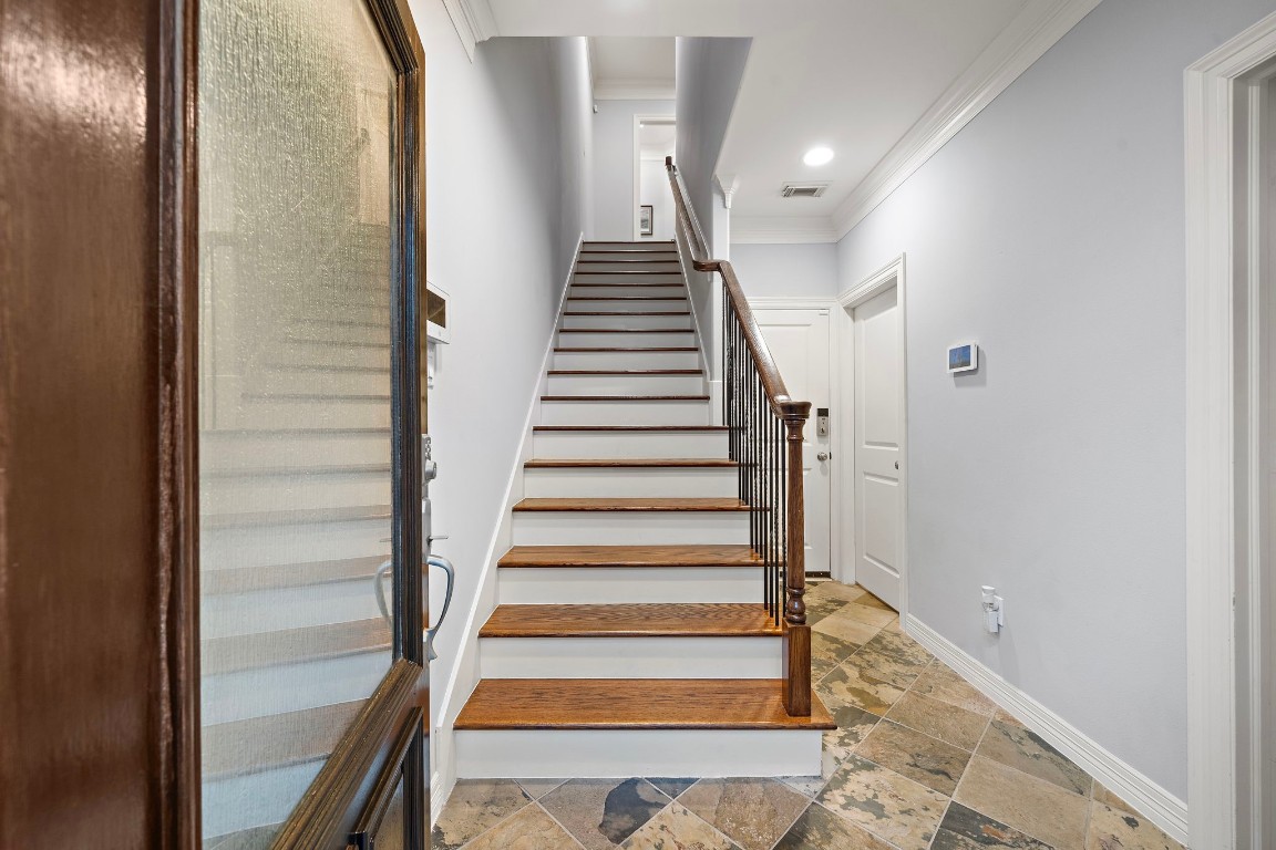 3929 Floyd Street Houston, TX 77007 - Photo 8 of 42 Welcoming foyer features a blend of classic stone-look tile flooring and elegant hardwood stairs with an iron railing.