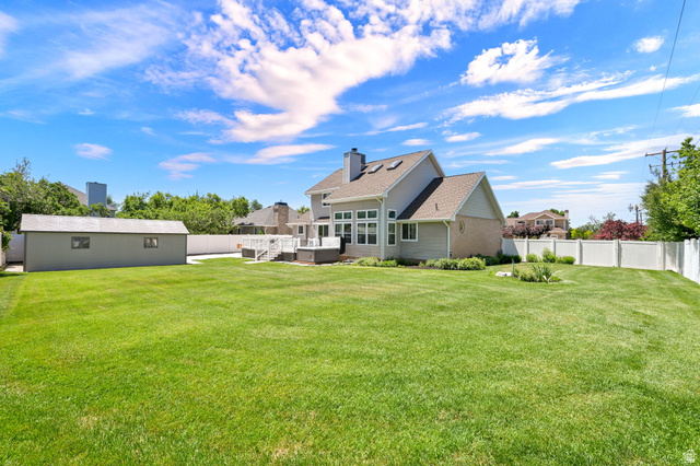 4792 Glasmann Way South Ogden, UT 84403 - Photo 25 of 70 Expansive green lawn bordering a light-sided home with large deck and second drive through gate on the north side of property