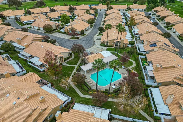 an aerial view of a residential building with swimming pool and outdoor seating