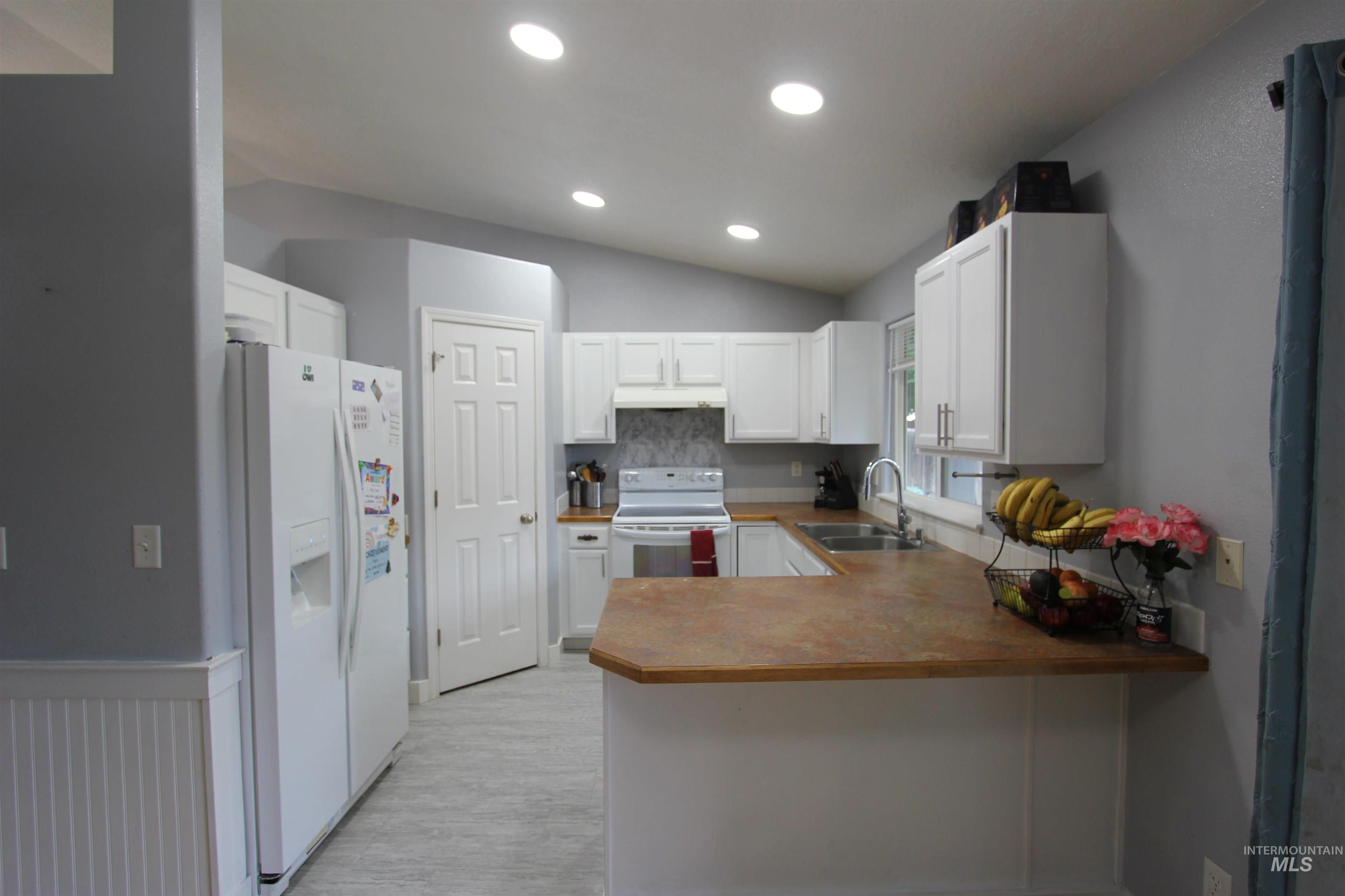 4816 Kadie Street Caldwell, ID 83607 - Photo 9 of 23 Kitchen featuring white cabinetry, a U-shaped countertop configuration, recessed lighting, and light-toned flooring