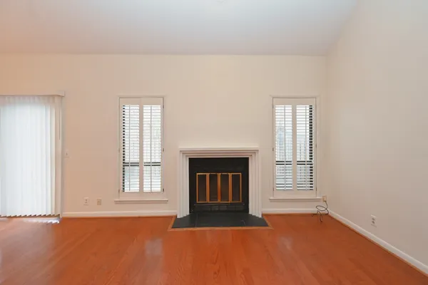 a view of an empty room with chandelier fan