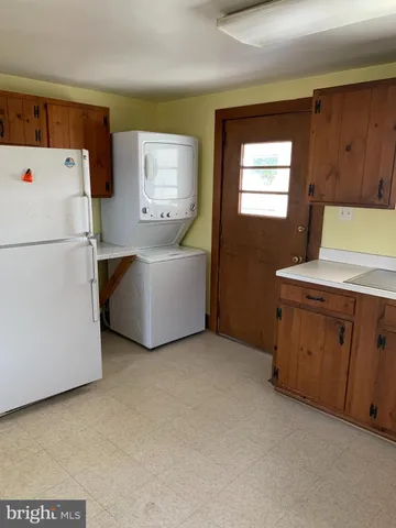 a view of kitchen with furniture and refrigerator