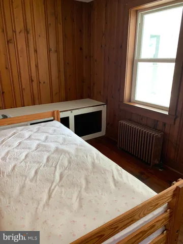 a view of empty room with wooden floor and fireplace