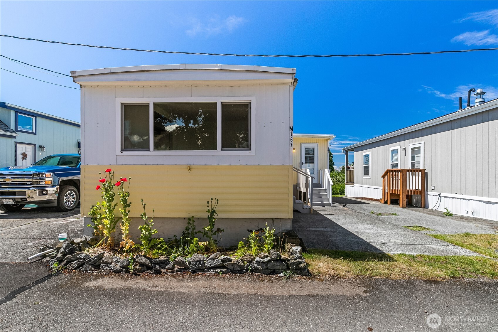 8080 Harborview Road, Unit 167 Blaine, WA 98230 - Photo 2 of 27 a front view of a house with a yard