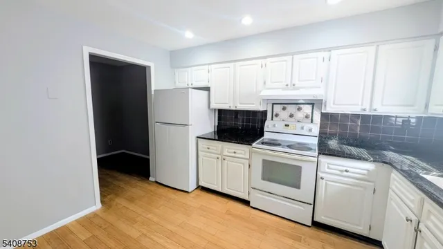 a kitchen with white cabinets and white appliances