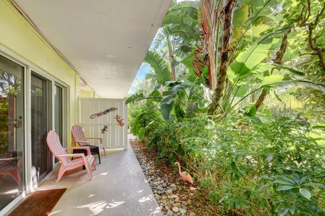 a patio with table and chairs and potted plants