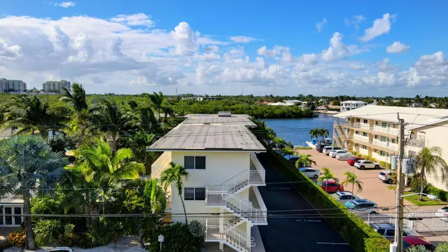 an aerial view of a city with lots of residential buildings ocean and mountain view in back