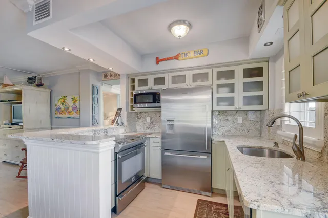 a kitchen with stainless steel appliances granite countertop a refrigerator and a sink