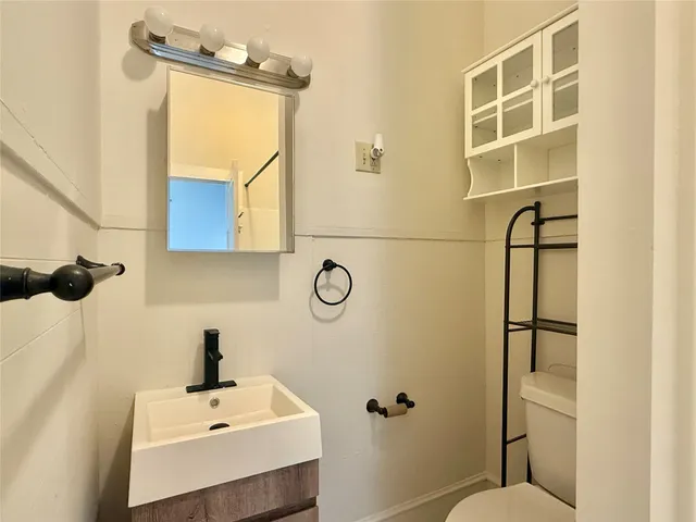 a bathroom with a sink mirror and toilet