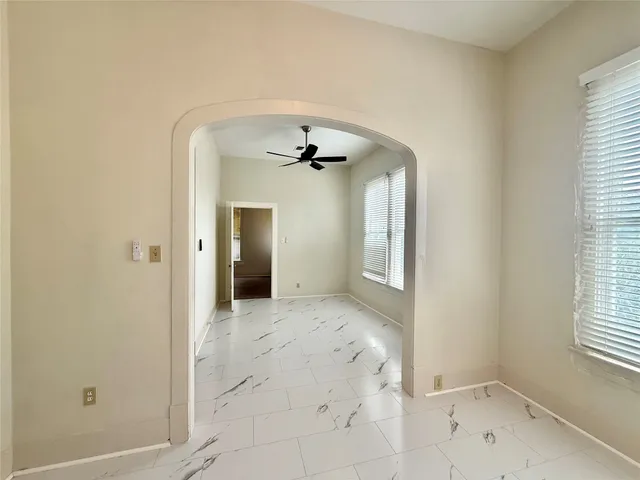 a view of a big room with windows and chandelier fan