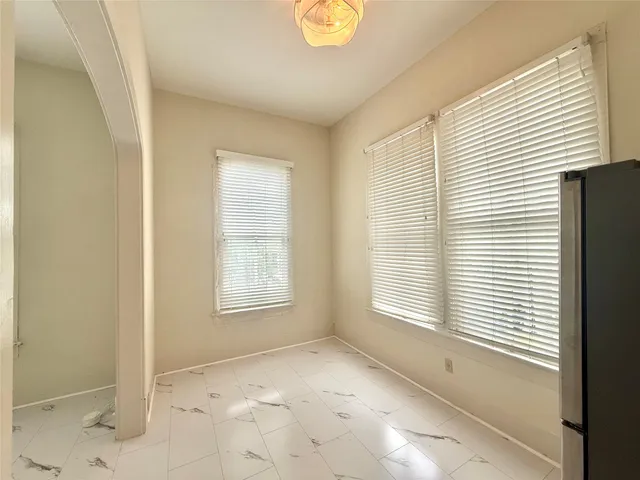 a view of an empty room with window and bathroom