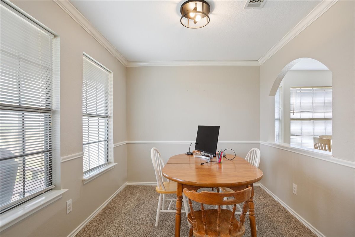 8600 Five Wells Road Rogers, TX 76569 - Photo 32 of 40 Carpeted dining area with ornamental molding and arched walkways