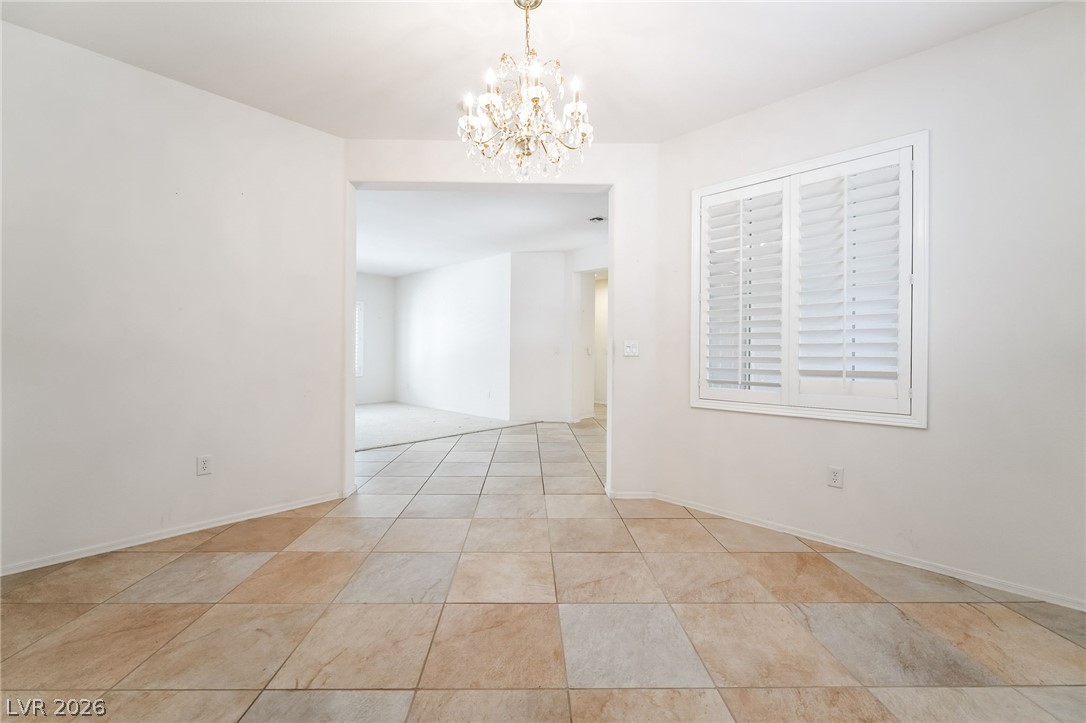3033 Hartsville Road Henderson, NV 89052 - Photo 12 of 41 Ornate chandelier and tiled floors establish a grand entrance, flowing seamlessly into the adjacent rooms.