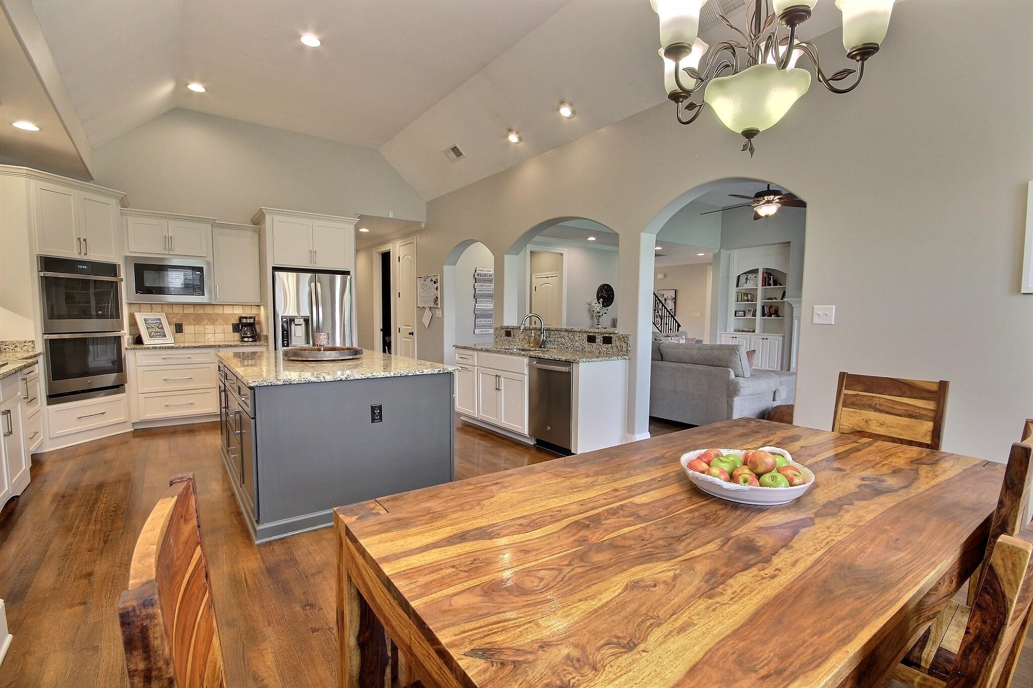 1707 Totty Lane Collierville, TN 38017 - Photo 16 of 40 a kitchen with stainless steel appliances kitchen island granite countertop a table chairs sink and stove