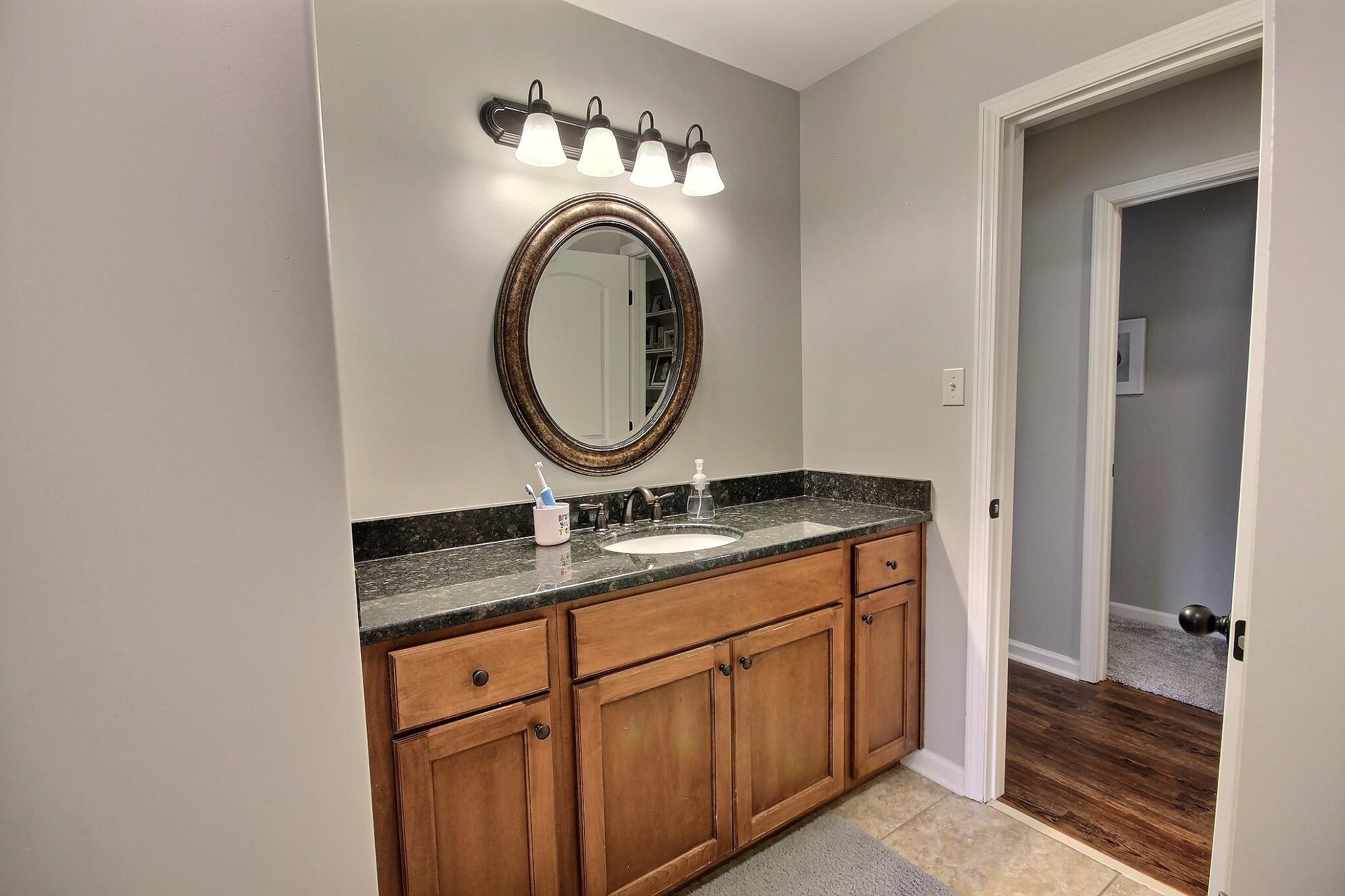1707 Totty Lane Collierville, TN 38017 - Photo 22 of 40 a bathroom with a granite countertop sink a mirror and toilet