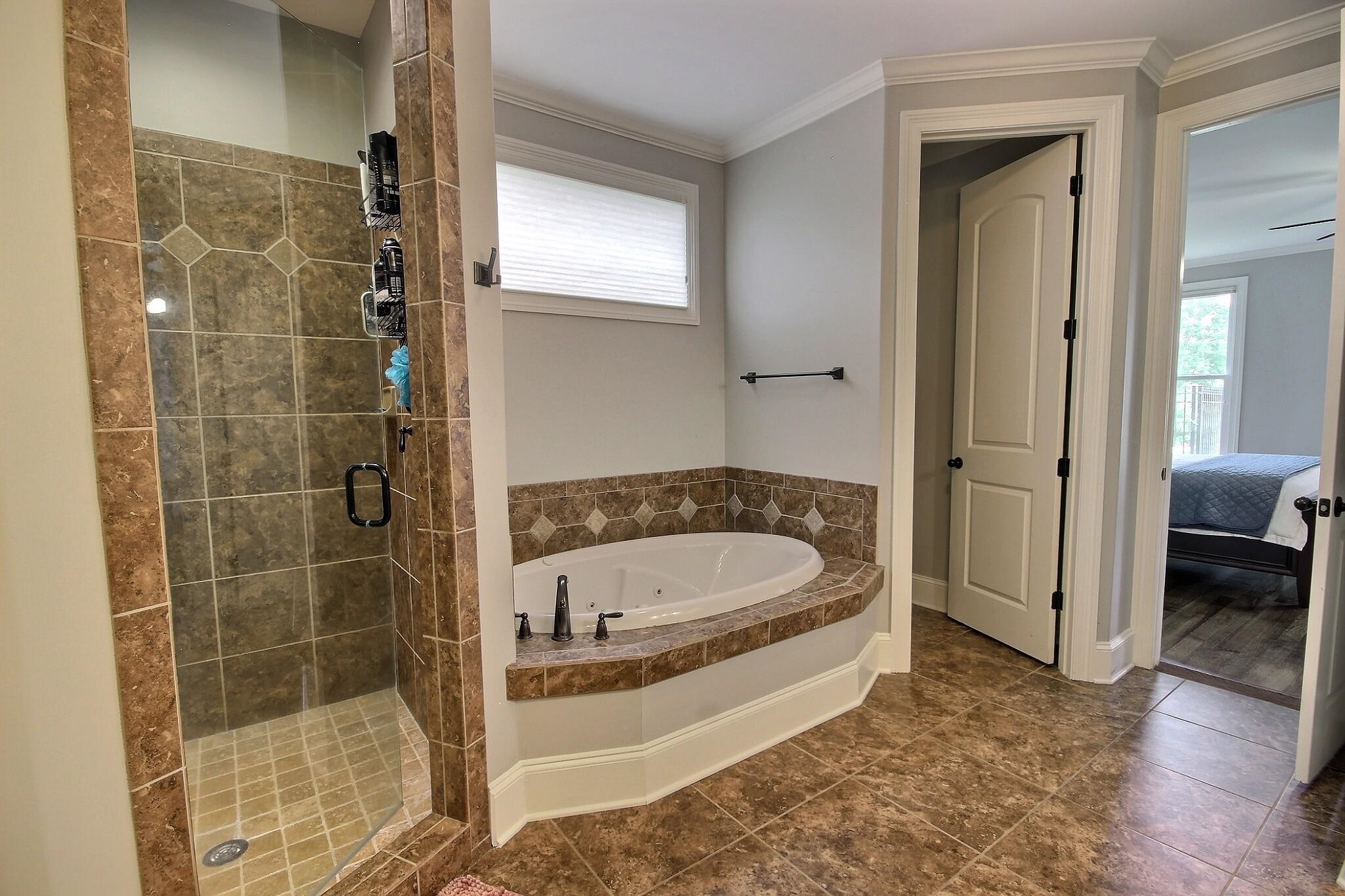 1707 Totty Lane Collierville, TN 38017 - Photo 9 of 40 a bathroom with a tub a window and a shower