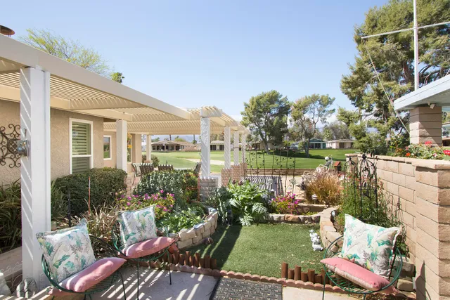 a view of a patio with couches table and chairs and potted plants