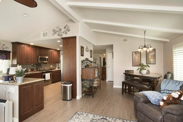 a living room with furniture a dining table and chairs with wooden floor