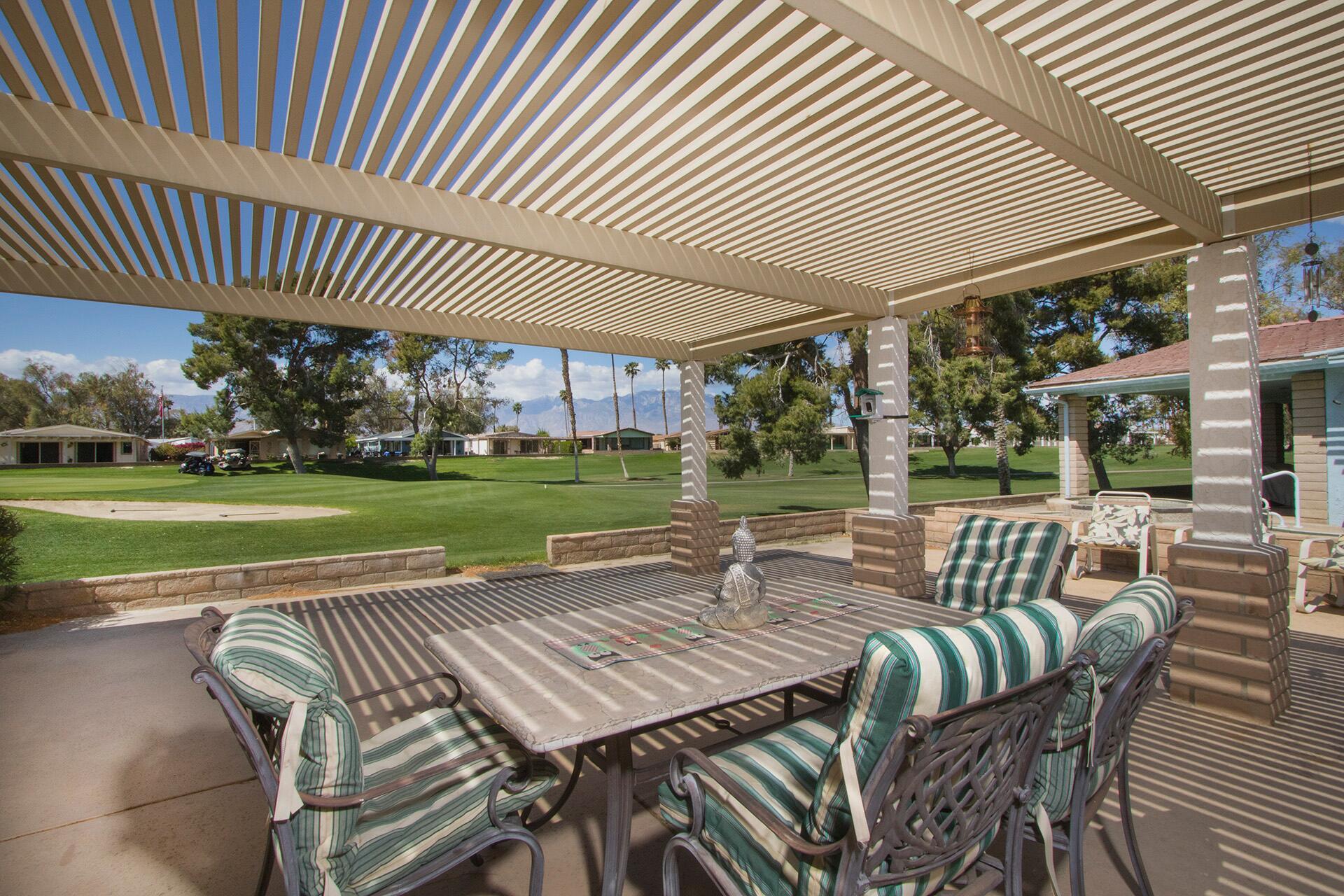 34649 Double Diamond Drive Thousand Palms, CA 92276 - Photo 32 of 42 a view of a patio with a table chairs and a backyard