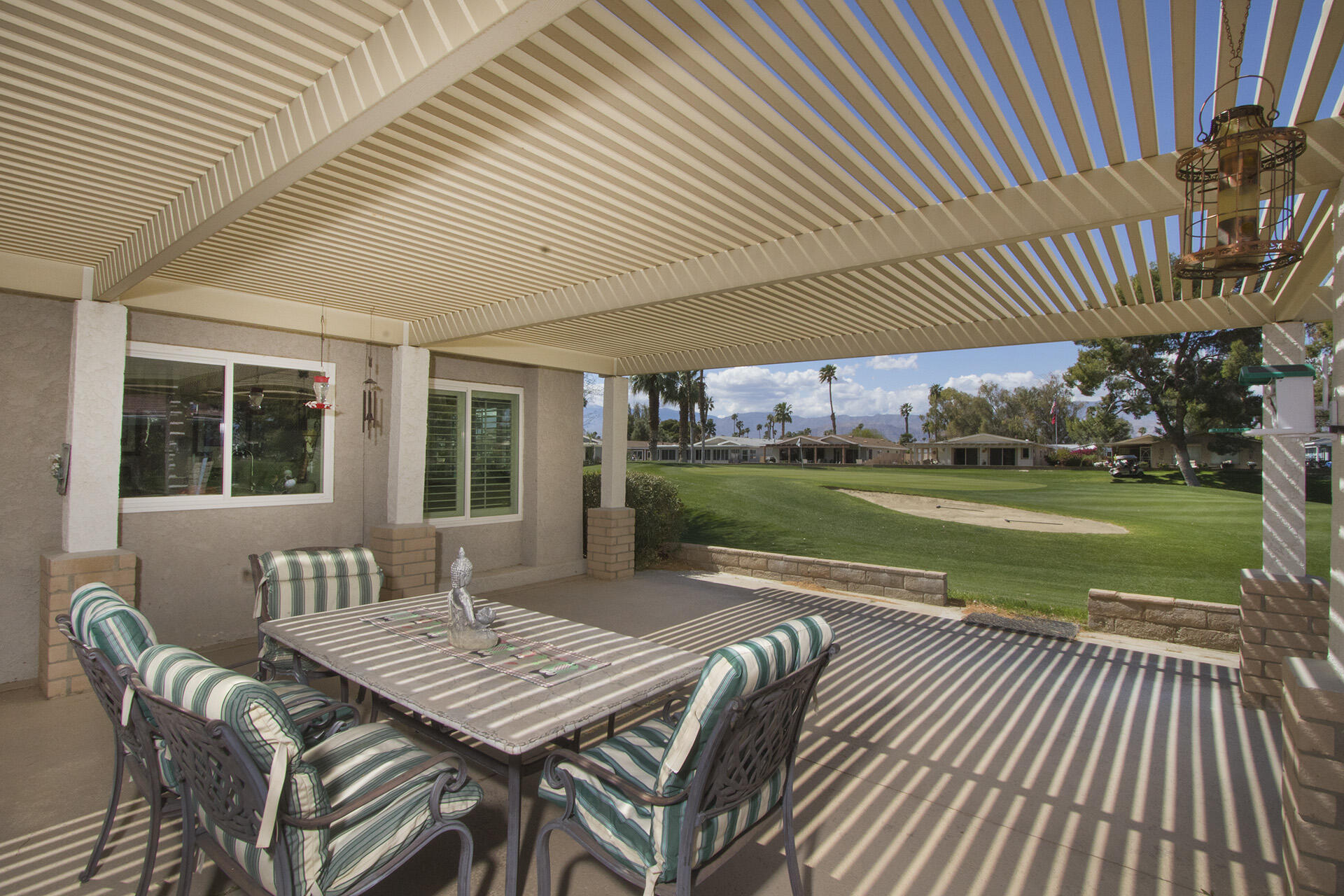 34649 Double Diamond Drive Thousand Palms, CA 92276 - Photo 33 of 42 a view of a patio with a table chairs and a backyard