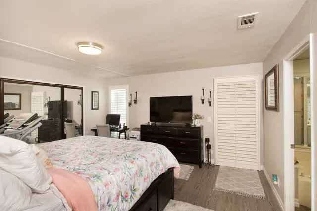 a bedroom with a bed and a flat tv screen