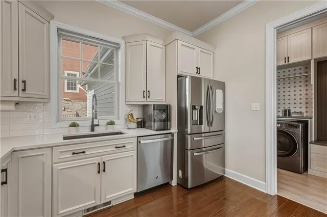 a kitchen with white cabinets and stainless steel appliances