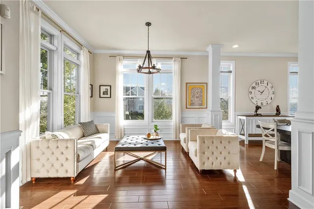 a living room with furniture wooden floor and a chandelier
