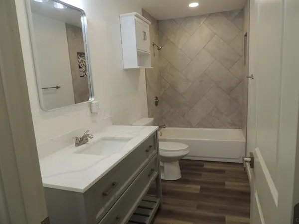 a bathroom with a sink a toilet and shower