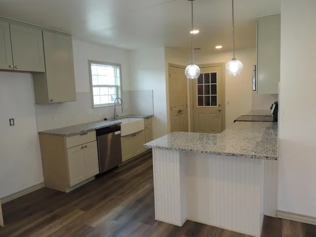 a kitchen with a sink window and cabinets