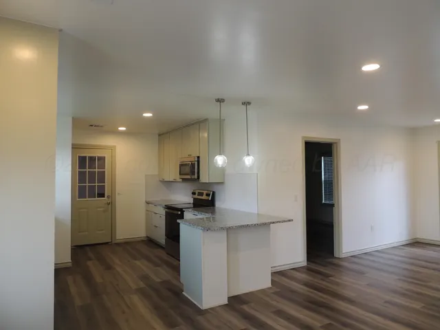 a kitchen with stainless steel appliances granite countertop a refrigerator and a stove top oven