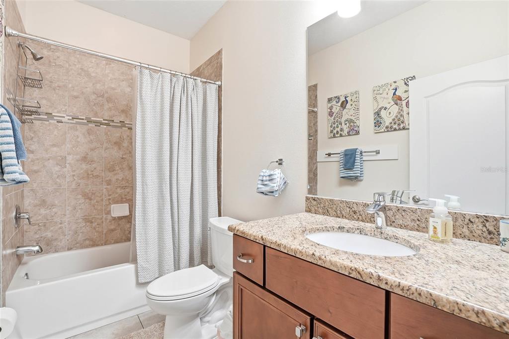 2906 West Douglas Street Tampa, FL 33607 - Photo 22 of 36 a bathroom with a granite countertop sink toilet and shower