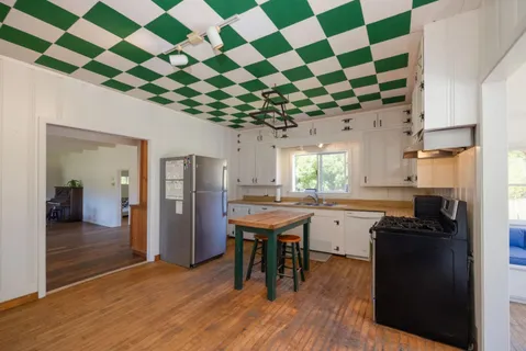a room with stainless steel appliances and chandelier