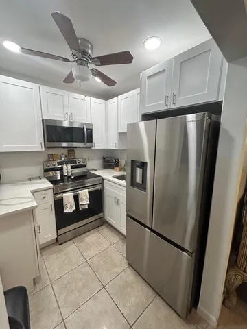 a kitchen with cabinets a refrigerator and a sink