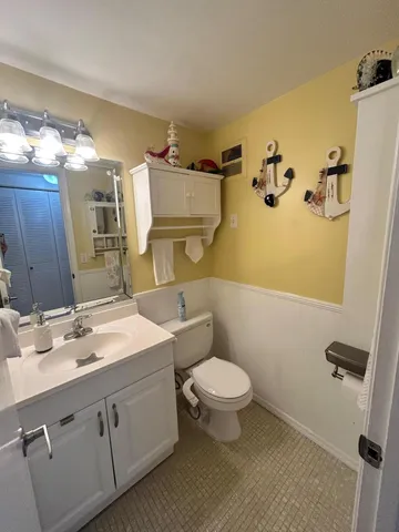 a bathroom with a sink mirror toilet and vanity