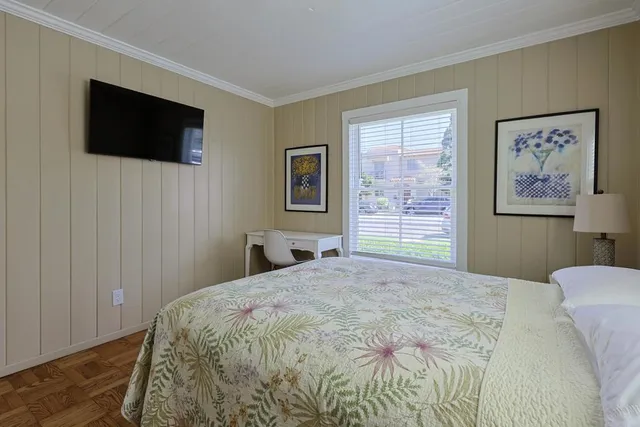 a bedroom with a bed tv and a window