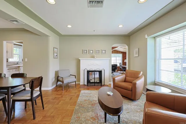 a living room with furniture a fireplace and a large window