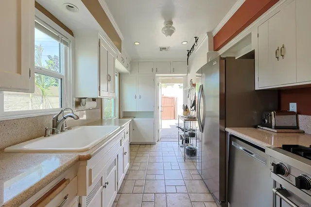 a kitchen with granite countertop a sink stove and refrigerator