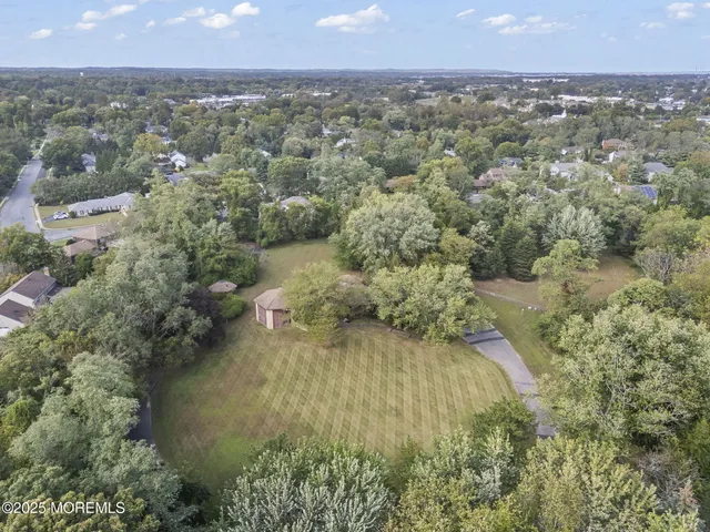 an aerial view of residential houses with outdoor space and trees