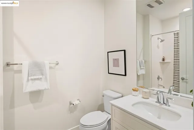 a bathroom with a toilet sink vanity and mirror