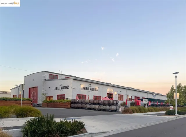 a large building with couple of cars parked in front of it