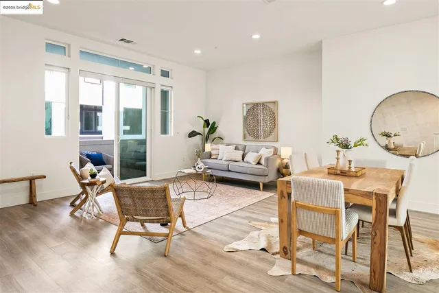 a living room with furniture a large window and wooden floor