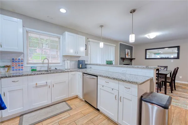 a kitchen with granite countertop white cabinets and window